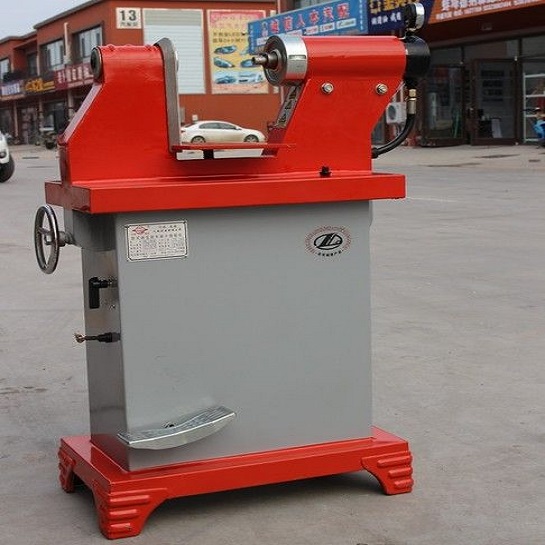 Máy tán má phanh thủy lực thân xám đầu tán màu đỏ đặt ngoài xưởng